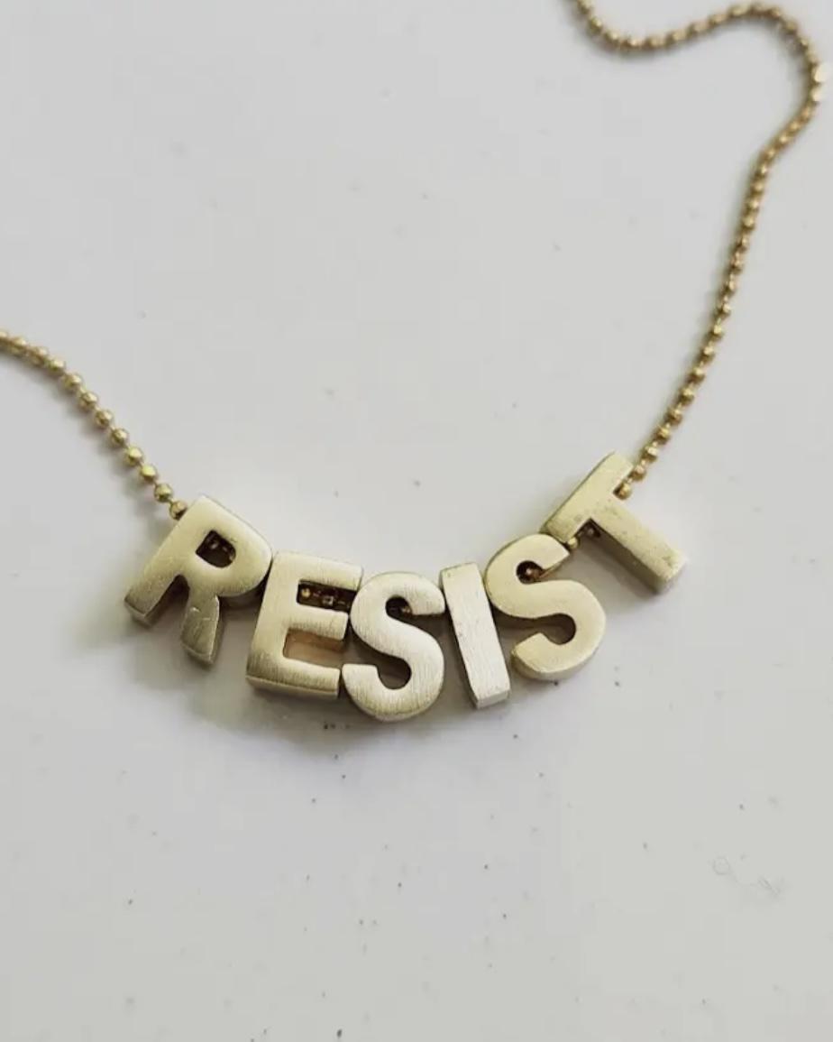 Sara Sela Brass RESIST Lettered Charm Necklace